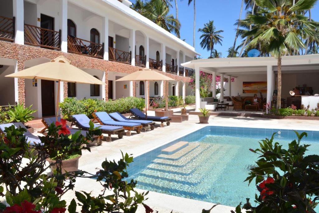 a hotel with a swimming pool in front of a building at Blu Marlin Village in Kiwengwa