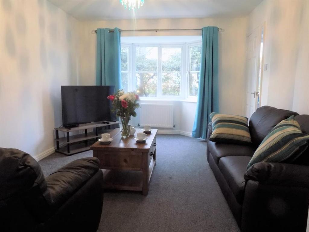 uma sala de estar com um sofá e uma mesa com uma televisão em Hive Close em Stockton-on-Tees