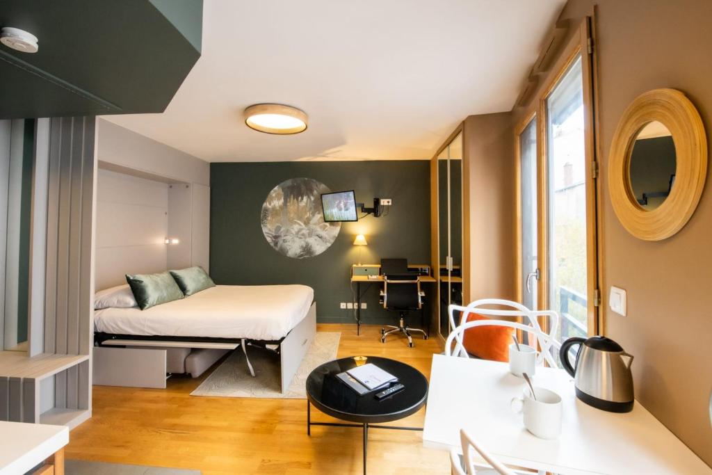 リヨンにあるLe Richan - 21 m au coeur de la Croix-Rousse climatiséのベッドとデスクが備わる小さな客室です。