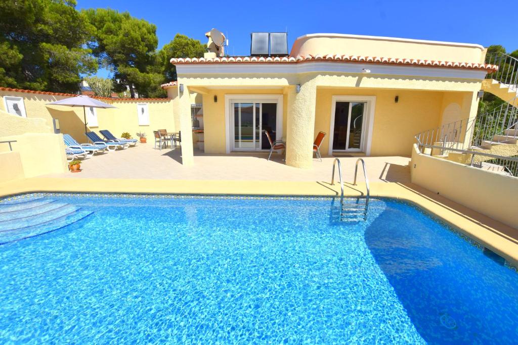 uma villa com piscina em frente a uma casa em Casa Feliz Javea em Balcon del Mar