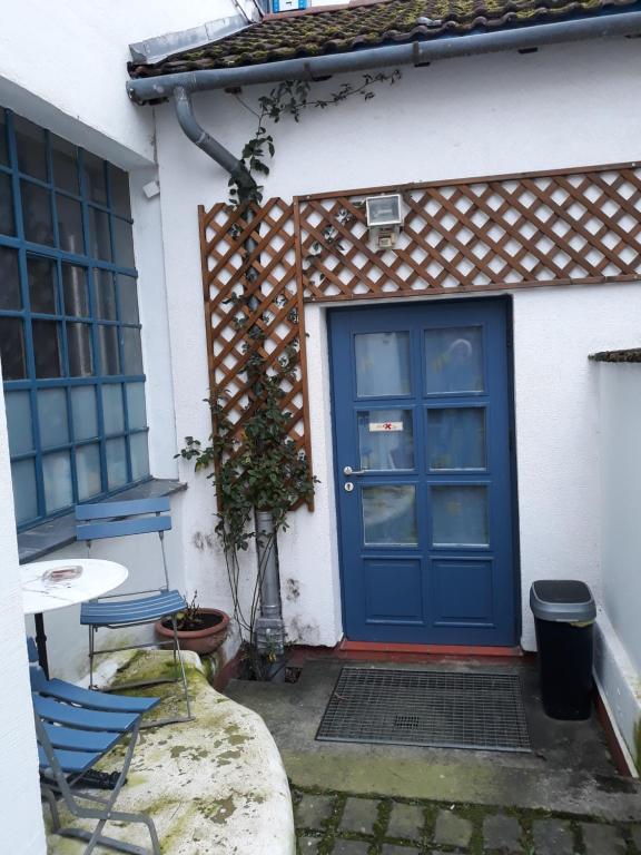 eine blaue Tür eines Hauses mit einem Tisch und Stühlen in der Unterkunft Kleines Häuschen in Ober-Ramstadt