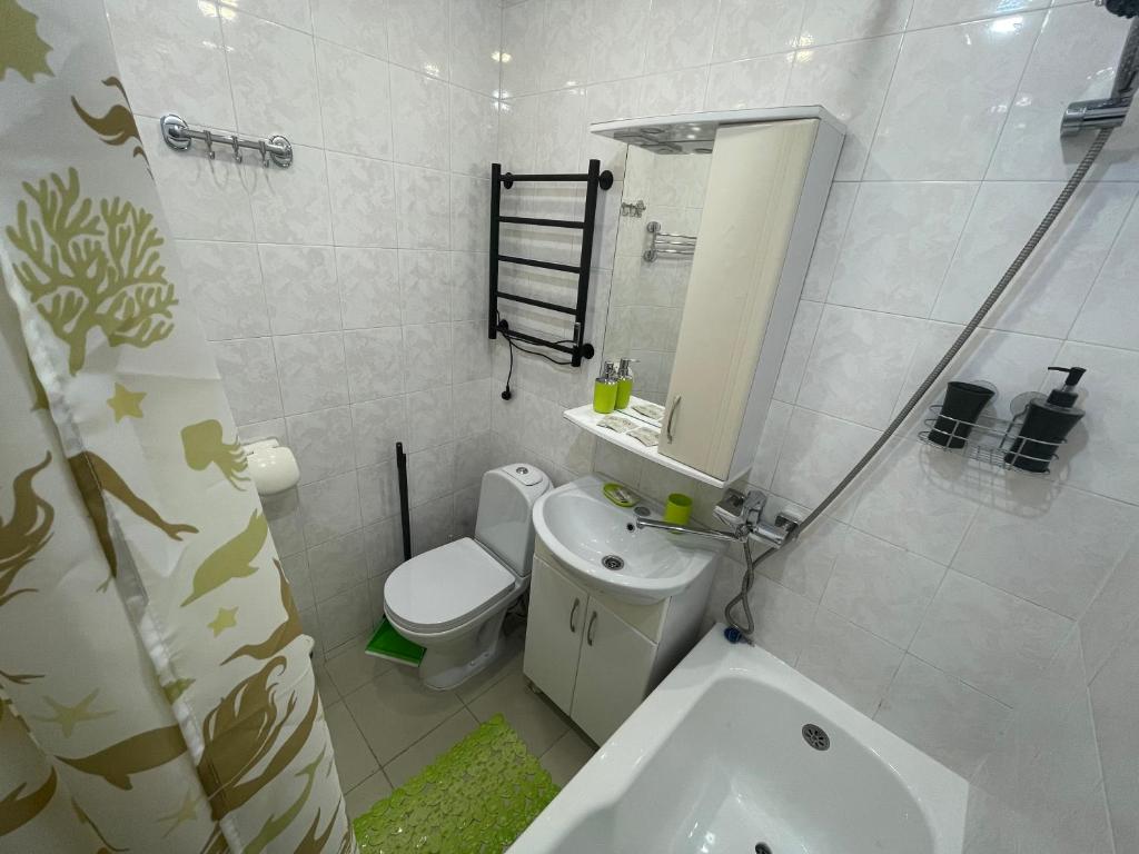 a white bathroom with a toilet and a sink at Апартаменты на Цветном бульваре in Sochi
