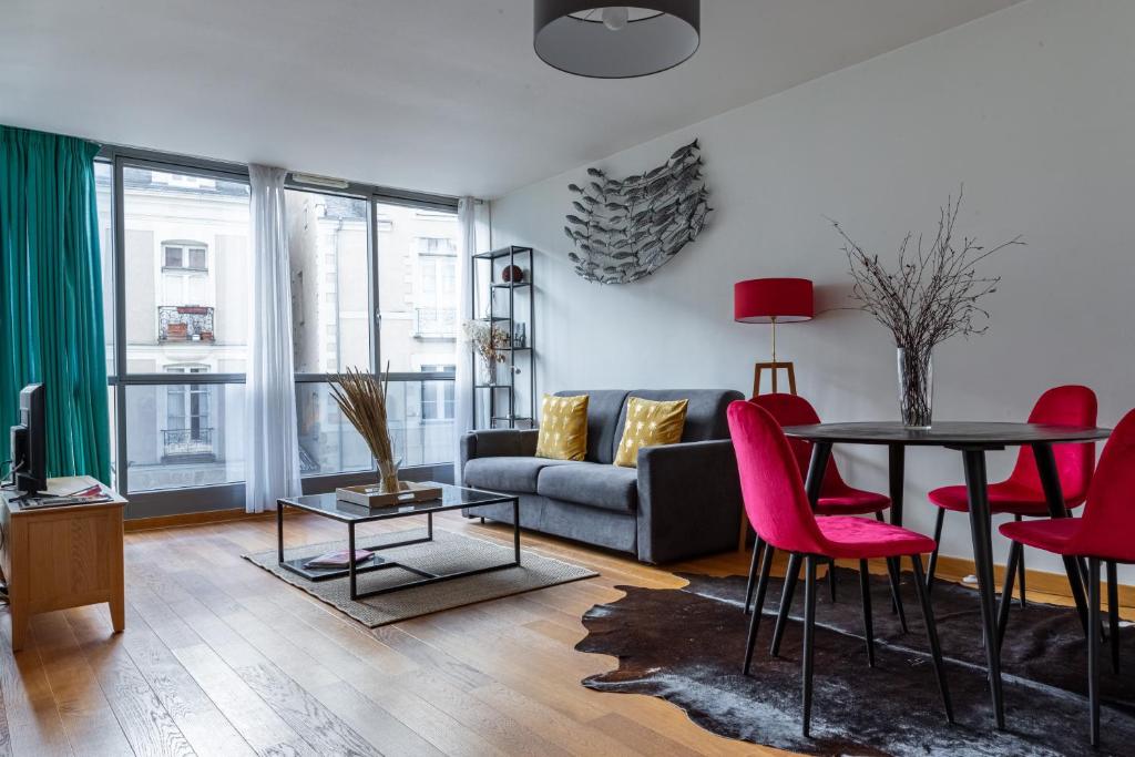 un salon avec un canapé, une table et des chaises dans l'établissement L'ECHAPPEE BELLE - T2 au cœur de Nantes, à Nantes