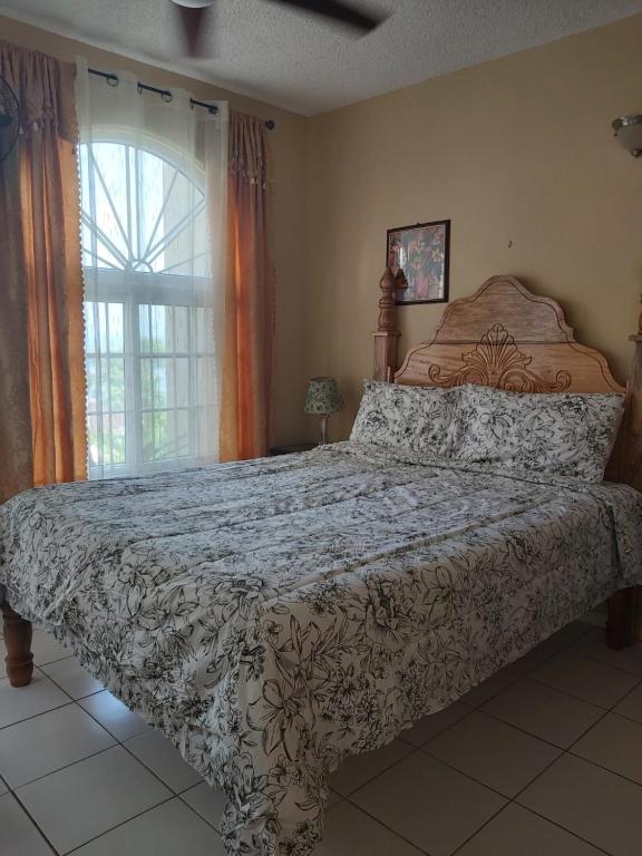 um quarto com uma cama grande e uma janela em Elegant Condo Awesome View em Ocho Rios