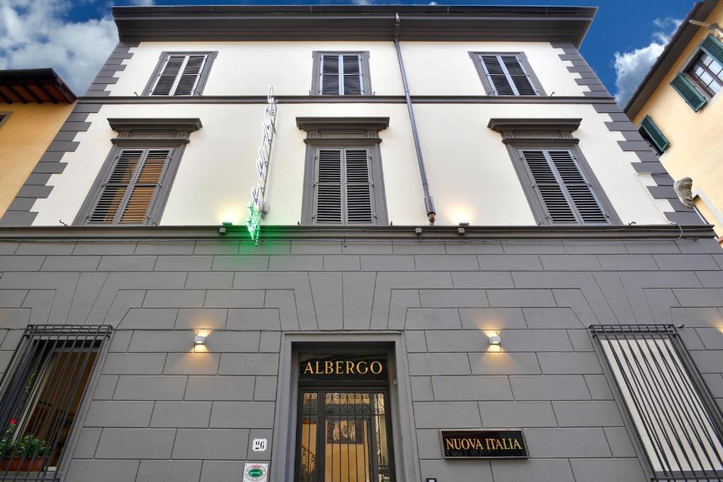 a tall white building with a sign above a door at Hotel Nuova Italia in Florence