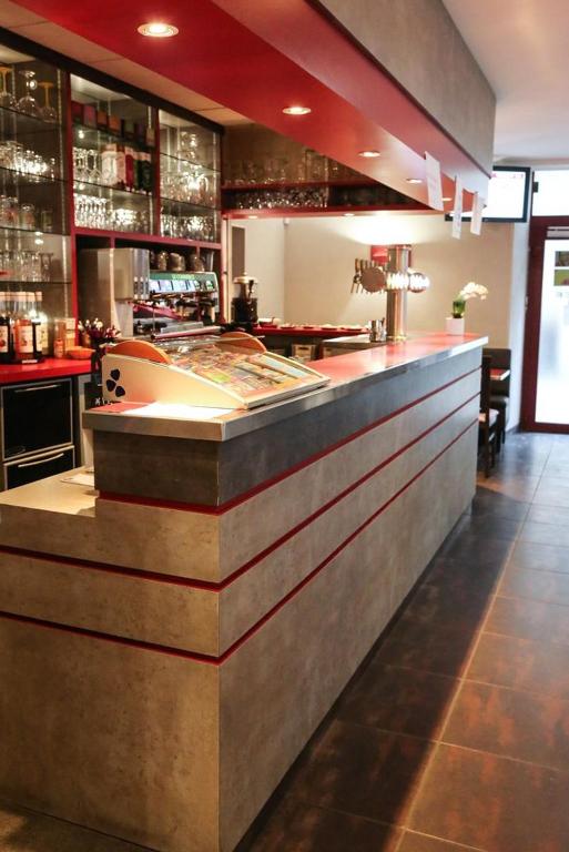 a bar in a restaurant with a counter at HOTEL DU COMMERCE in La Châtre