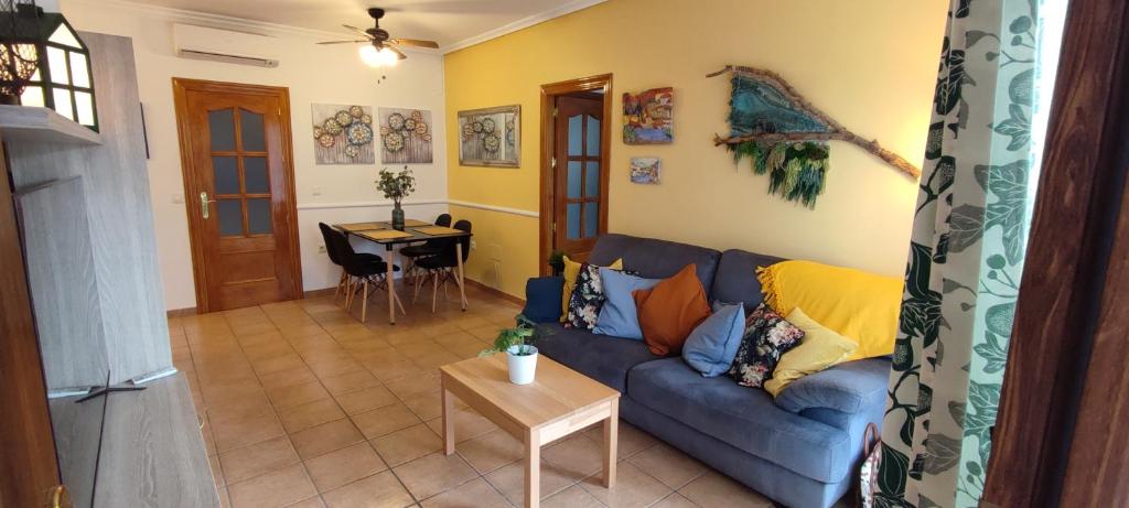 ein Wohnzimmer mit einem blauen Sofa und einem Tisch in der Unterkunft Casas-VeraPlaya Al Andalus Residencial Casa La Libertad in Vera