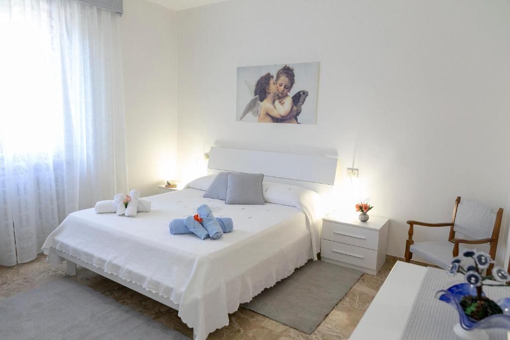 um quarto com uma cama branca com dois bichos de peluche em Appartamento Casa Vacanze Enjoy em Assis
