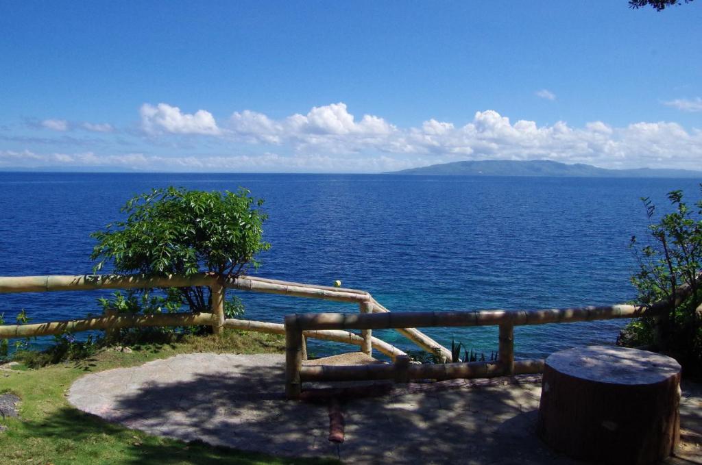 a view of the ocean with a wooden fence at Almira Diving Resort- Panglao in Panglao