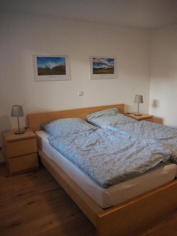 een bed in een slaapkamer met 2 nachtkastjes en 2 lampen bij Ferienwohnung Dinkelbergblick in Wehr