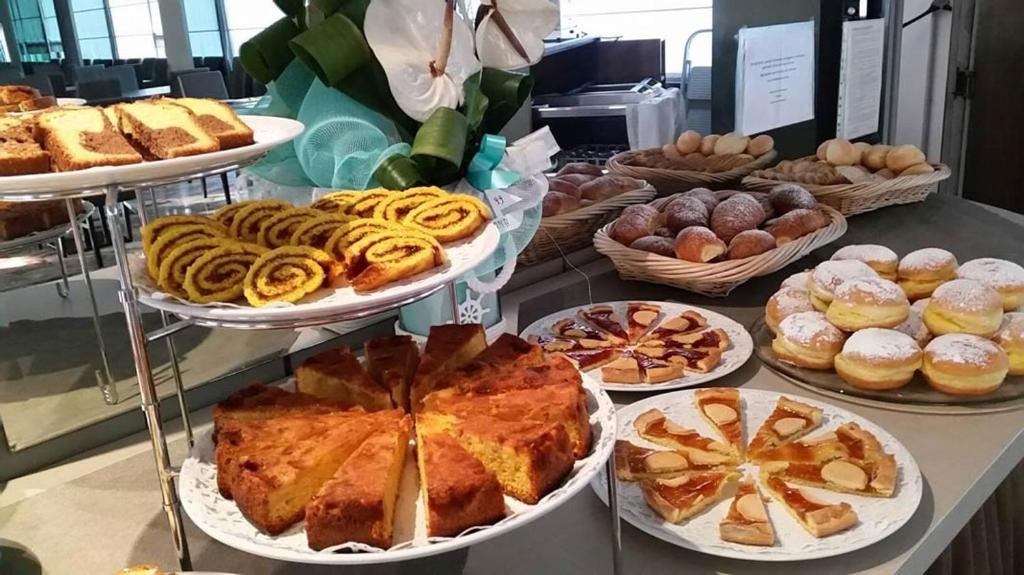 uma mesa com diferentes tipos de pães e doces em Bes Hotel Bergamo Ovest em Mozzo