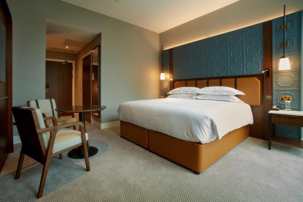 a bedroom with a bed and a table and a chair at The Parkgate Hotel in Cardiff