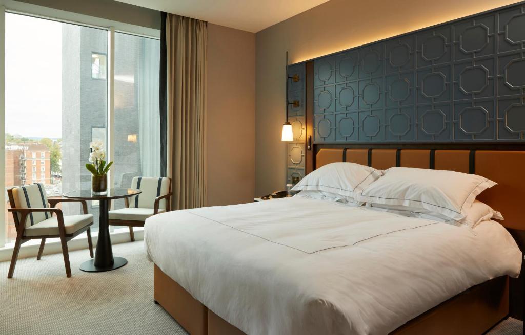 a bedroom with a large bed and a table at The Parkgate Hotel in Cardiff