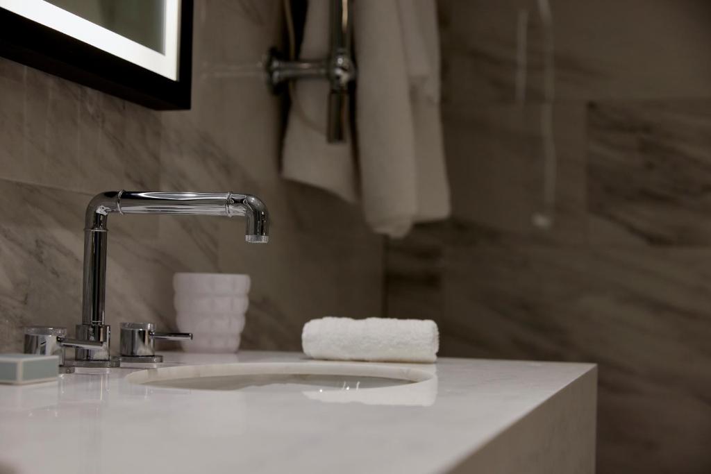 a bathroom sink with a faucet and a towel at The Parkgate Hotel in Cardiff