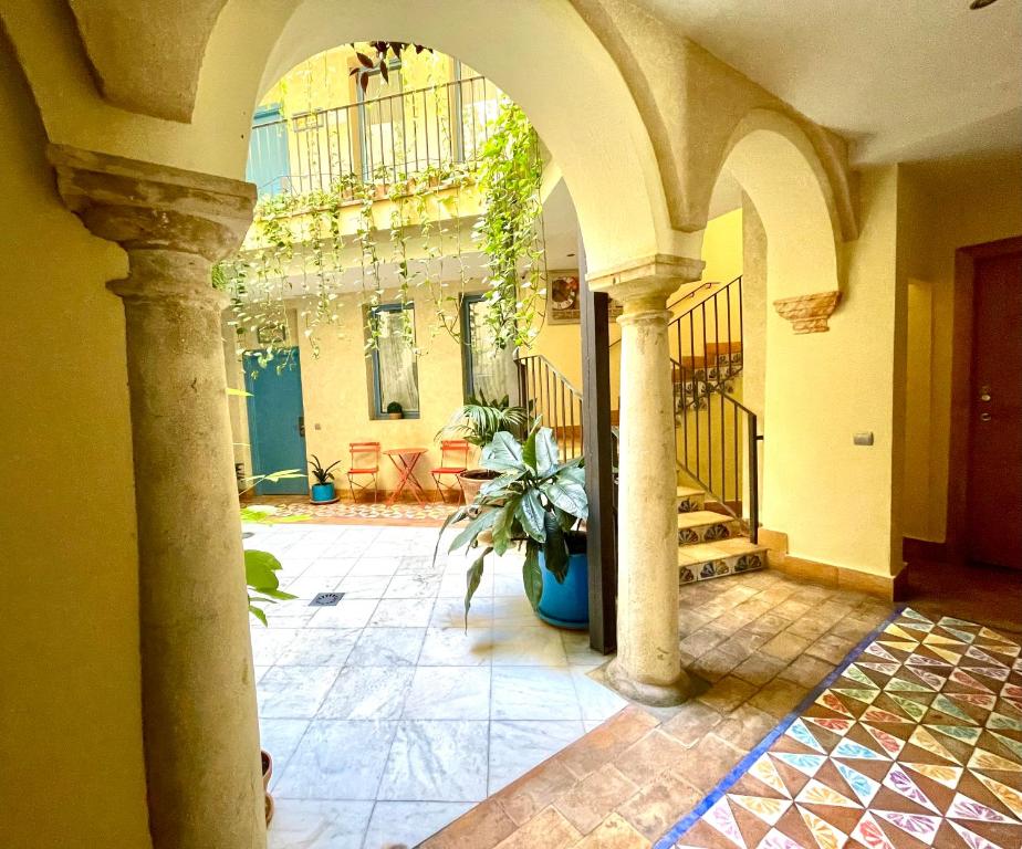 a hallway with columns and a building with a potted plant at Hotel Conde de Cárdenas in Córdoba
