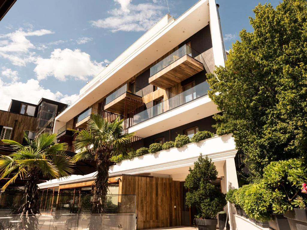 un immeuble d'appartements avec des plantes sur la façade dans l'établissement Select Hill Resort, à Tirana