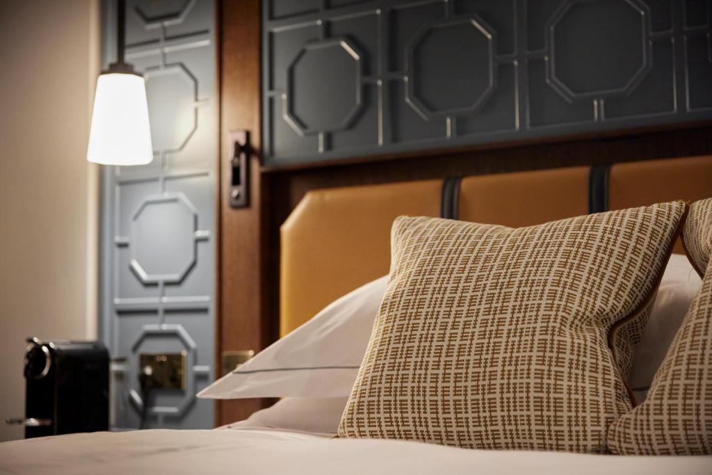 a bed with a headboard and a pillow on it at The Parkgate Hotel in Cardiff