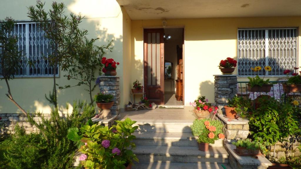 una casa con piante in vaso sul portico anteriore di Al 12 a Marina di Pisa