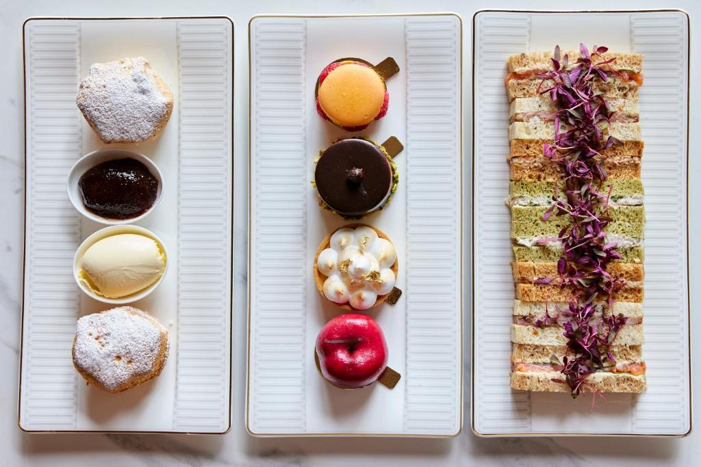 four white plates with different types of food on them at The Parkgate Hotel in Cardiff