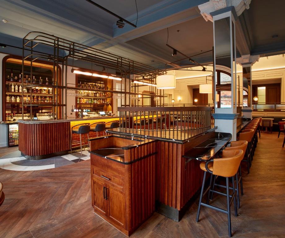 a bar in a restaurant with wooden tables and chairs at The Parkgate Hotel in Cardiff