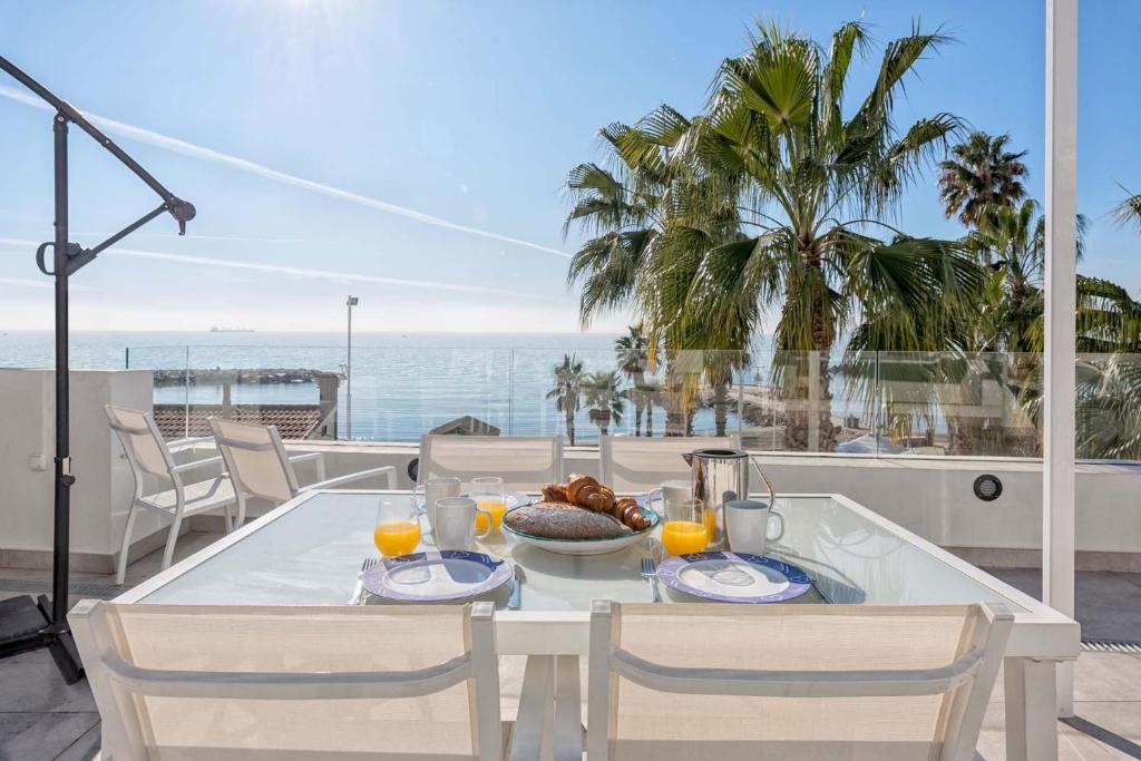 a white table with a plate of food on a balcony at Solaga - Miguel in Málaga