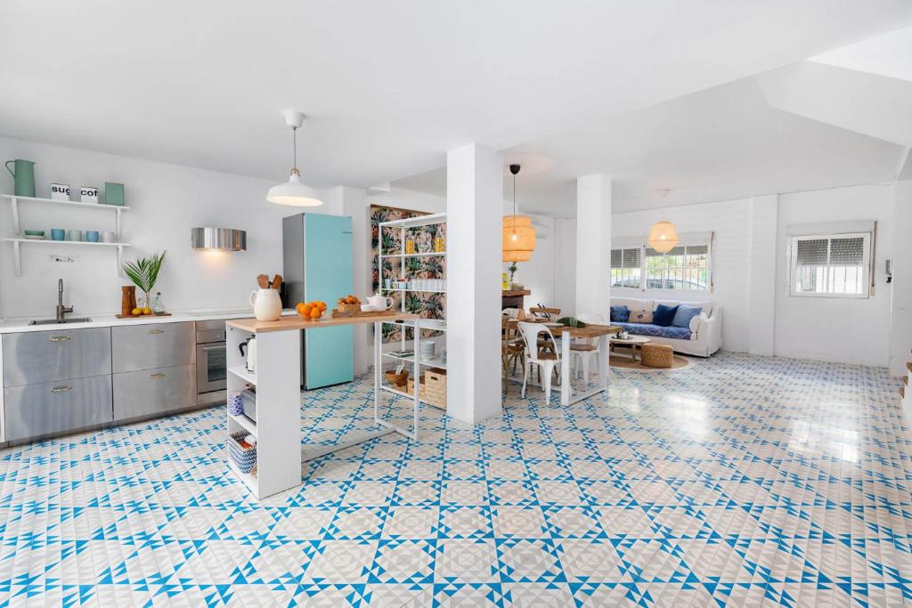 eine Küche und ein Wohnzimmer mit blauen und weißen Fliesen in der Unterkunft Solaga - Chuita in Málaga