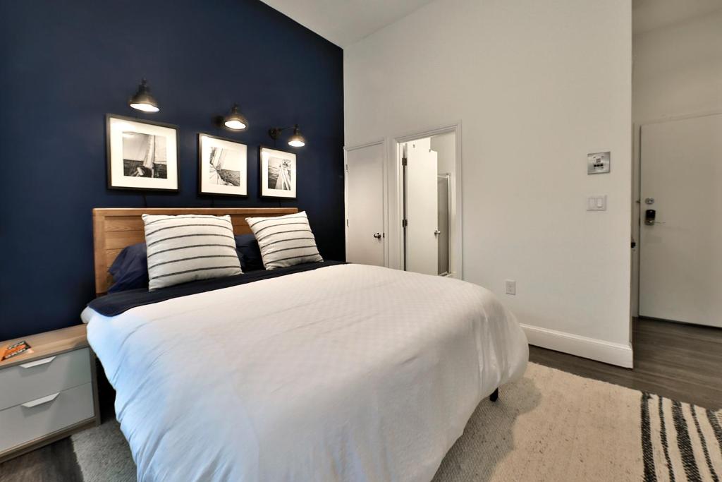 a bedroom with a large white bed with blue walls at Good Hotels Boston in Boston