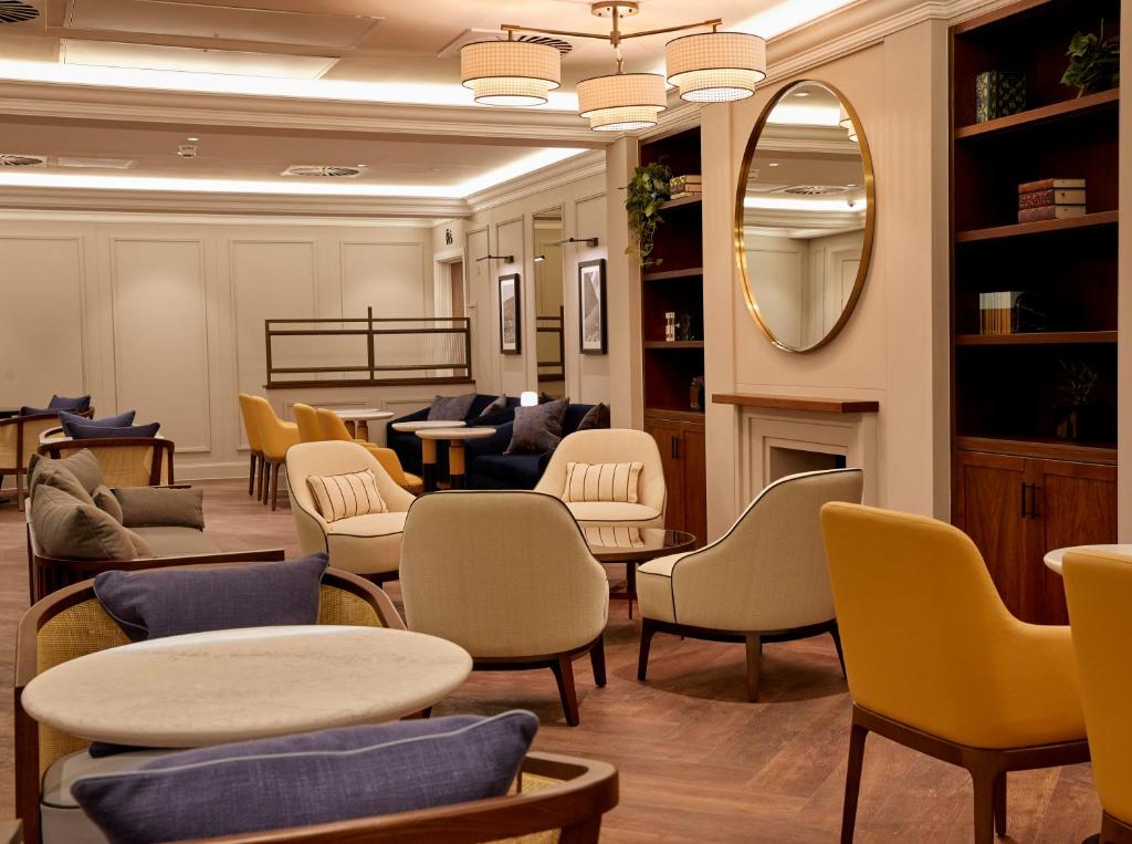 a waiting room with chairs and tables and a mirror at The Parkgate Hotel in Cardiff