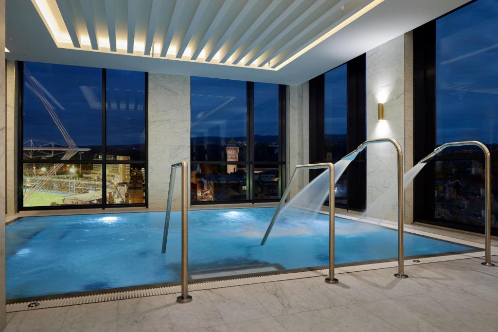 a swimming pool in a building with a large window at The Parkgate Hotel in Cardiff