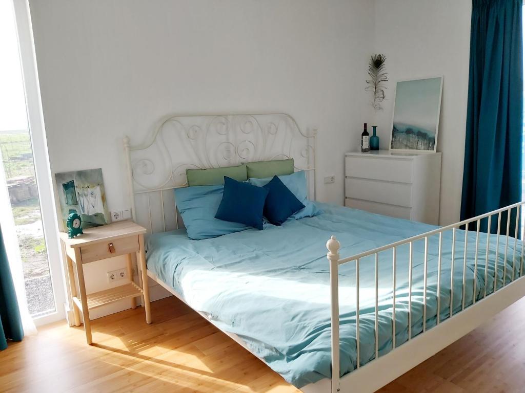 ein Schlafzimmer mit einem Bett mit blauen Kissen in der Unterkunft Luxury Suites Oosterwold in Almere