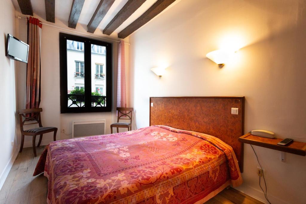 a bedroom with a bed and a window at Résidence de Bourgogne in Paris