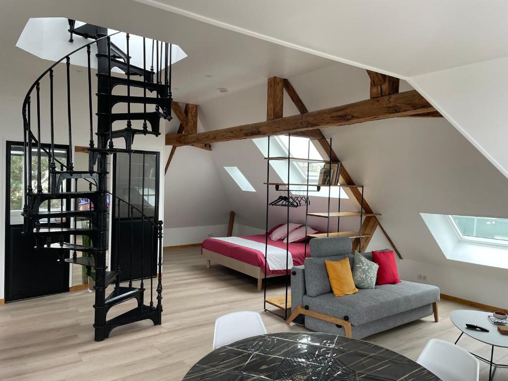 uma escada em espiral numa sala de estar com um sofá em Le Loft de Flore em Dieppe