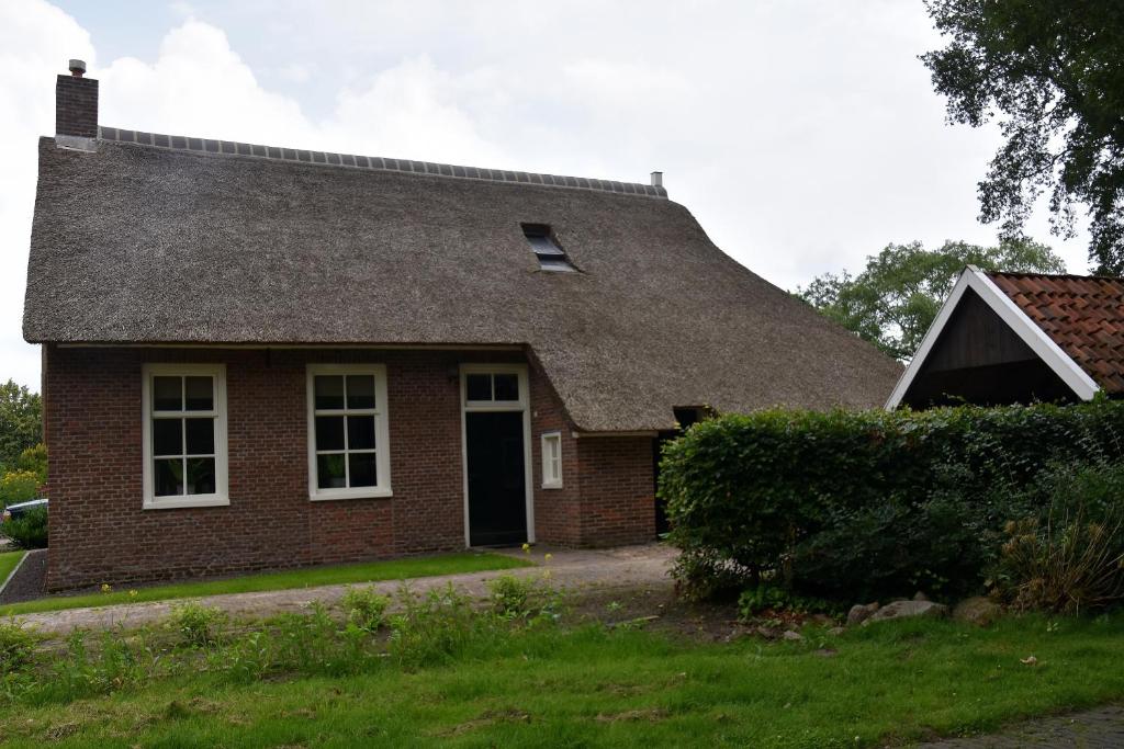 a red brick house with a gray roof at Typisch Norg in Norg