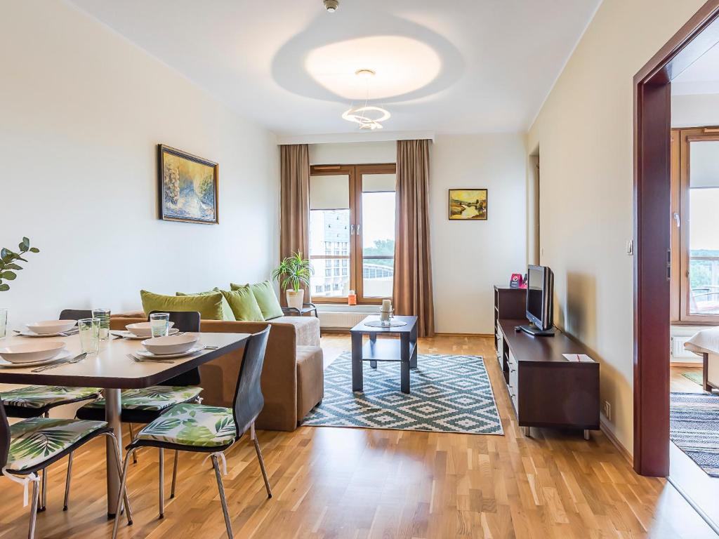 a living room with a couch and a table at VacationClub - Olympic Park Apartament C602 in Kołobrzeg