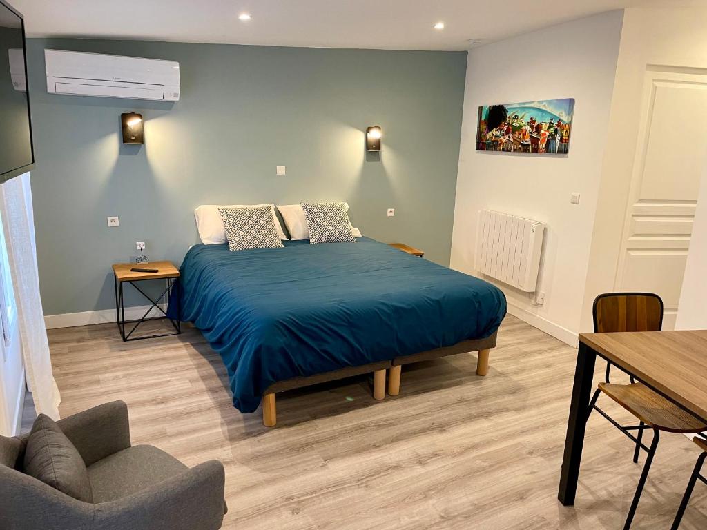 Un dormitorio con una cama con una manta azul. en Moulin 1- Appartement Arènes Romaines - Beziers centre - Wifi - Tv connectée en Béziers