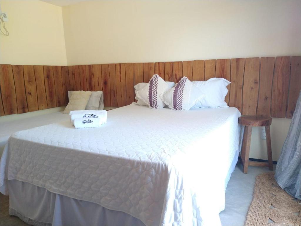 a bedroom with a bed with white sheets and pillows at Pousada Beira Rio Parnaíba in Parnaíba