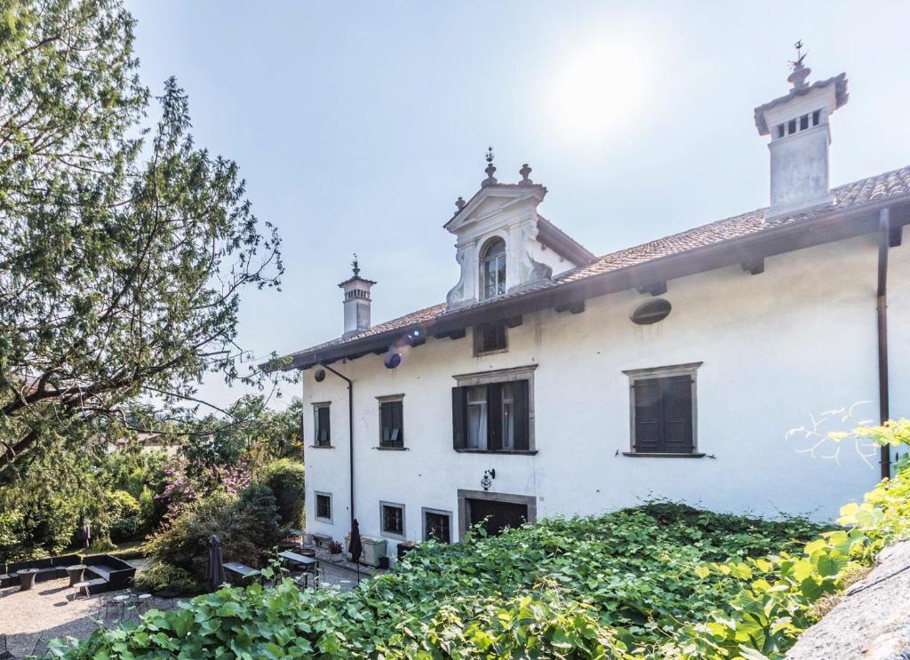 Une ancienne maison blanche avec une tour en haut dans l'établissement Villa De Rubeis Florit, à Tarcento