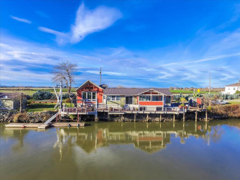 a house on a dock next to a body of water at Year-round fishing, boating, birding, 1 hr from SF in Walnut Grove
