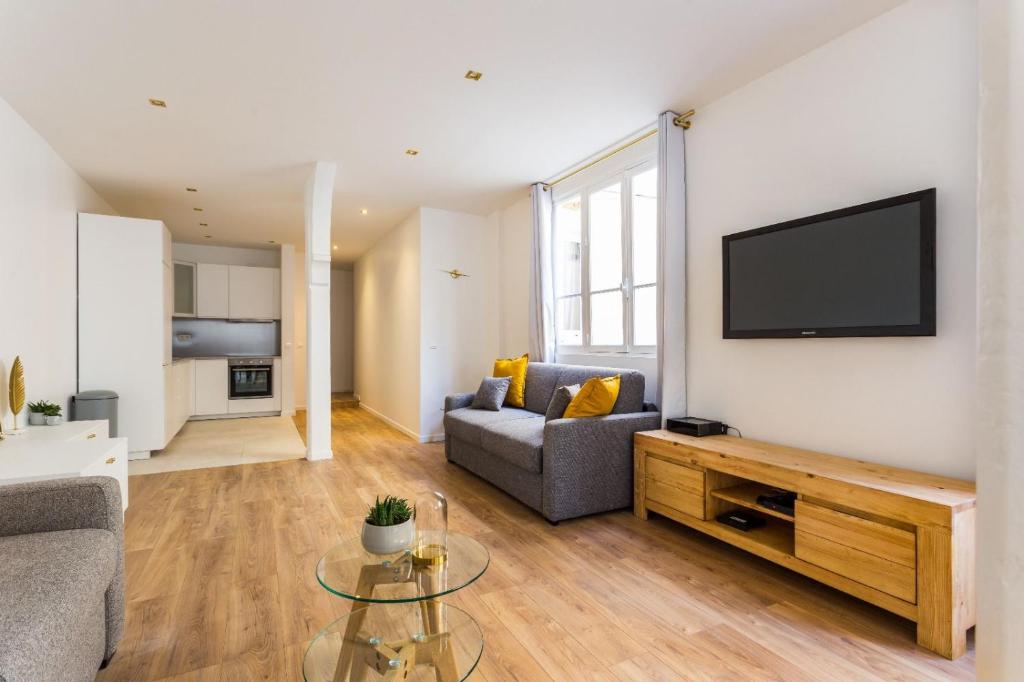 - un salon avec un canapé et une télévision murale dans l'établissement Appartement8P/Full Equipped/BONNE NOUVELLE/BOURSE, à Paris