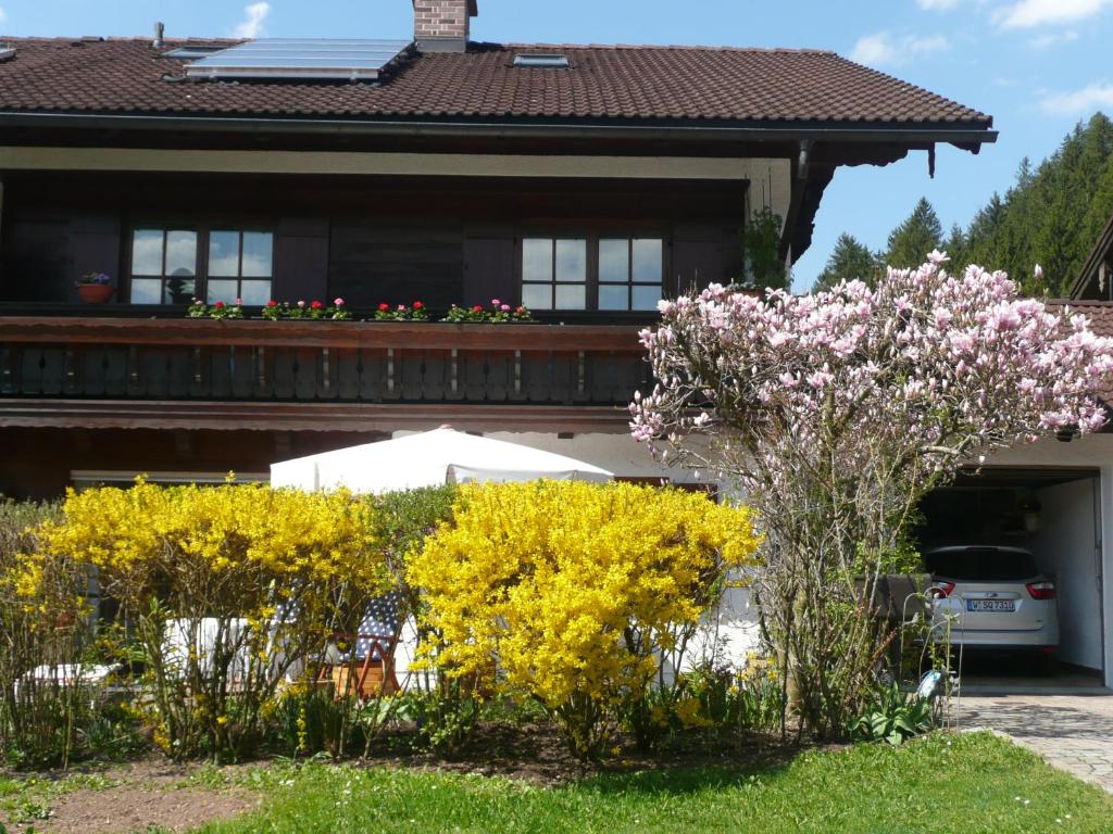 a house with a bunch of flowers in the yard at Ferienwohnung Gouiaa in Bischofswiesen