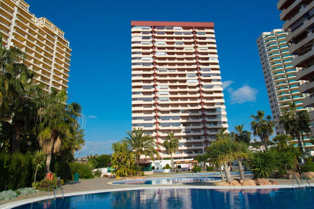 un hôtel avec une piscine en face de deux grands bâtiments dans l'établissement Coral Beach 37c, à Calp