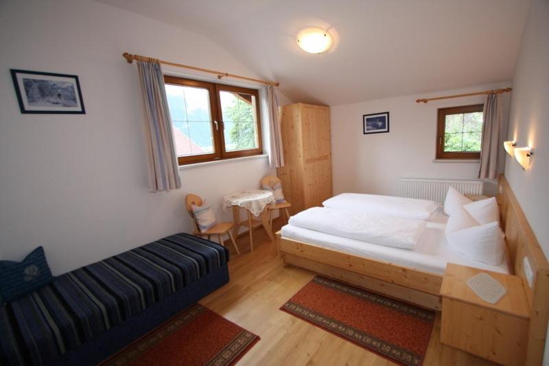 - une chambre avec un lit et un canapé dans l'établissement Oberstockachhof, à Schwendau