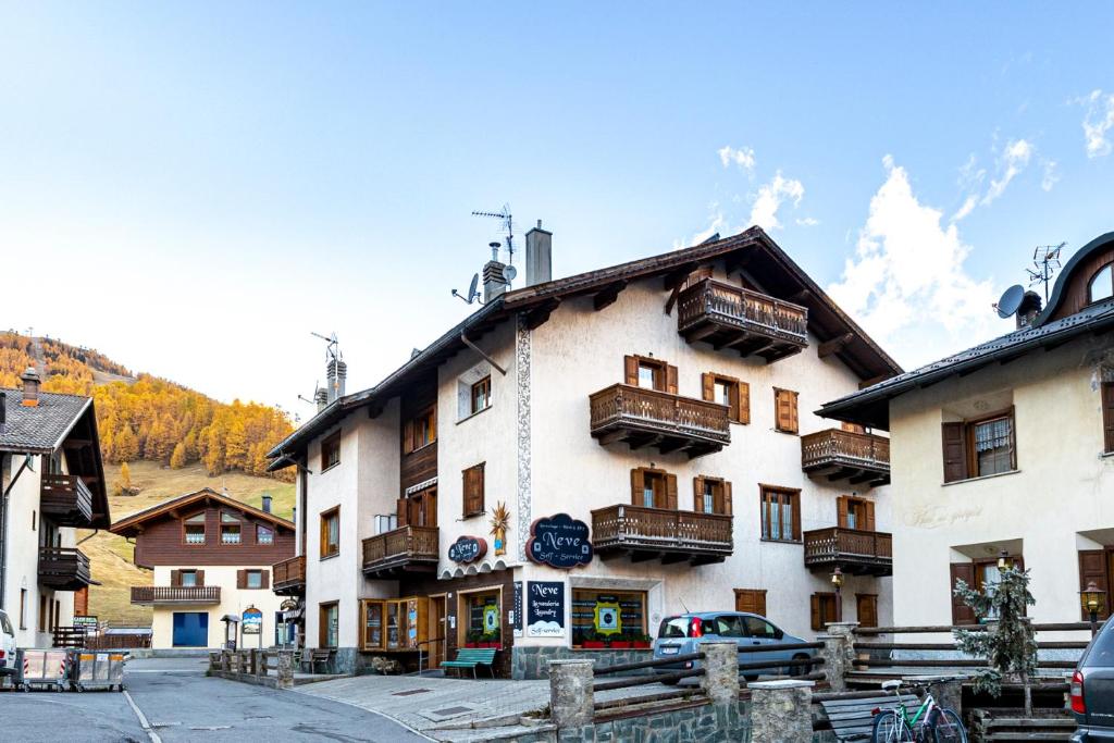 ein großes weißes Gebäude mit Balkon auf einer Straße in der Unterkunft Chalet La Nuvola in Livigno