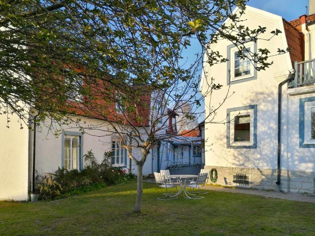 Ein Baum im Hof eines weißen Hauses in der Unterkunft Karl-Oskars Krypin in Visby