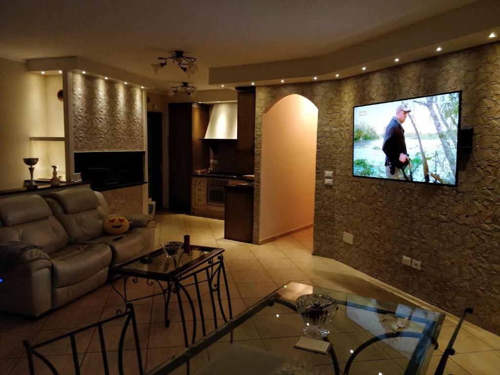 sala de estar con sofá y TV en la pared en Casa Riva, en Terni