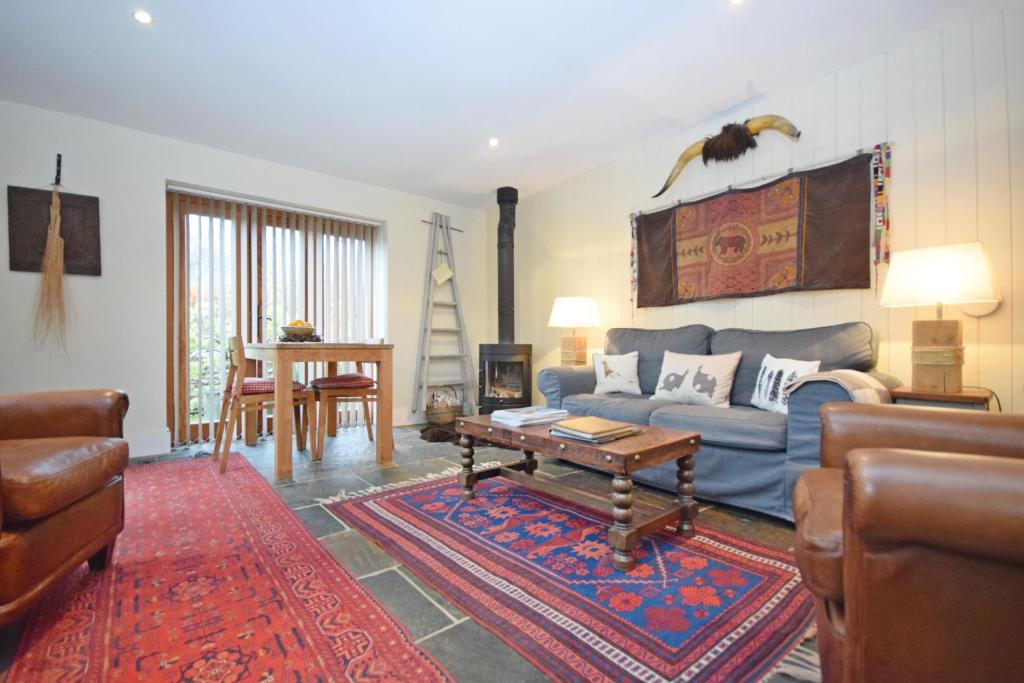 a living room with a blue couch and a table at The Barn at Guiles , Petersfield in Petersfield