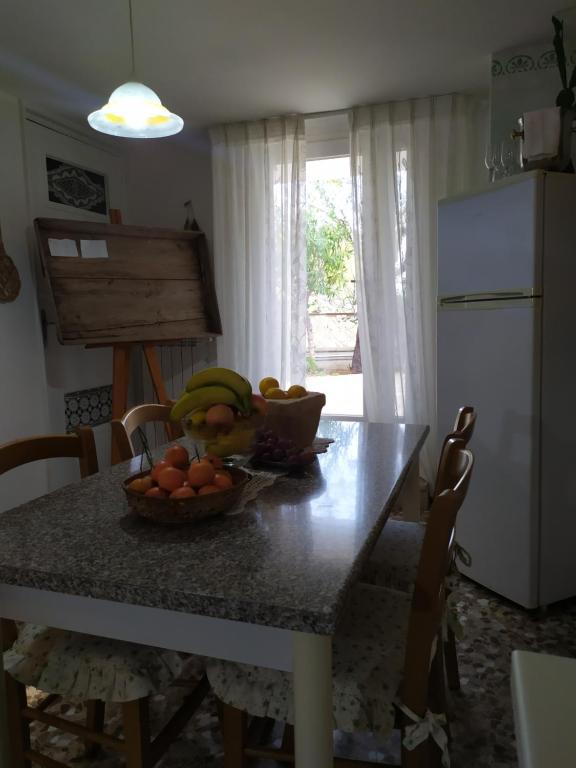 a kitchen table with a bowl of fruit on it at Casa dei sospiri in Polignano a Mare
