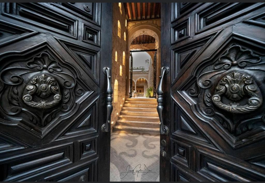 wejście do domu z drewnianymi drzwiami w obiekcie Casa Vieja Hotel Boutique w mieście Morelia