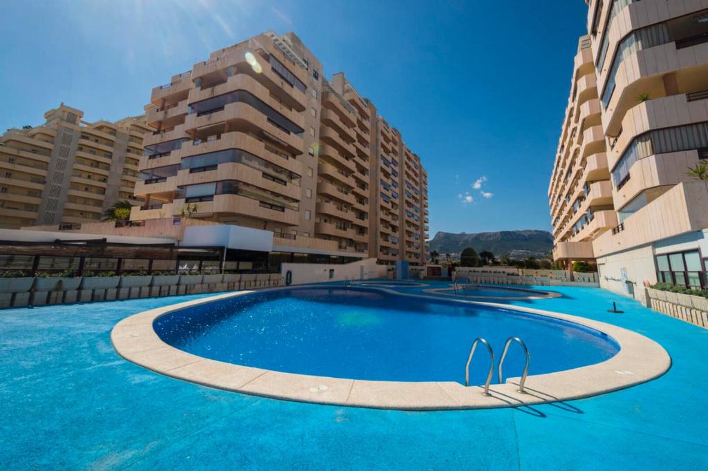 una grande piscina di fronte ad alcuni edifici alti di Topacio i 34b a Calpe