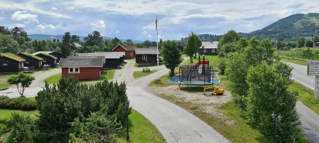 un pequeño pueblo con un parque infantil al lado de una carretera en Øen Turistsenter Cottages, en Geilo